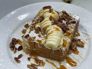 French toast with nuts, bananas, and syrup