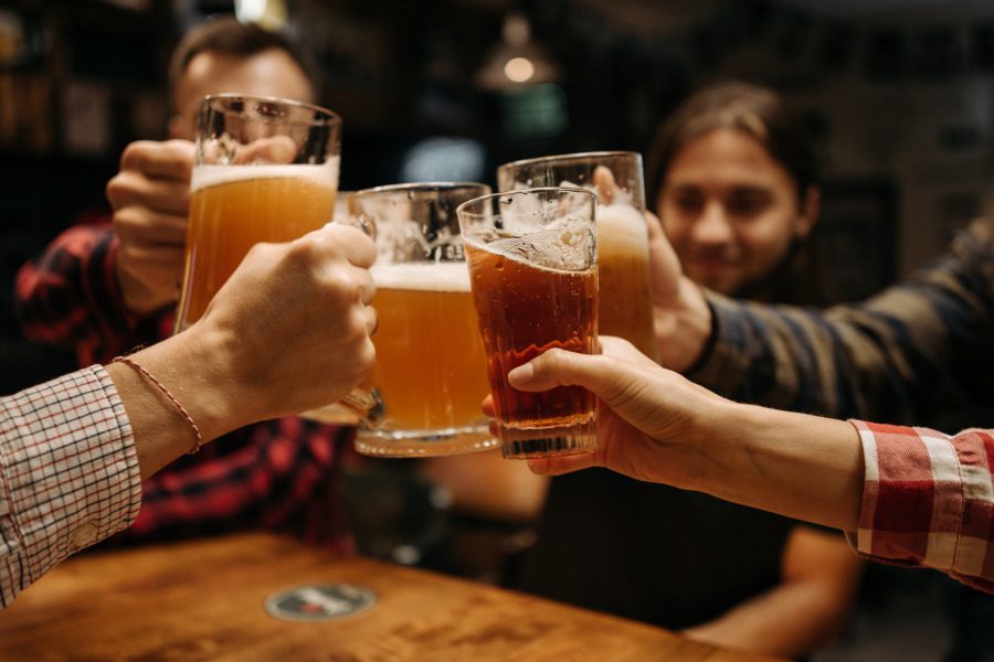 a group of guys clinking beer mugs