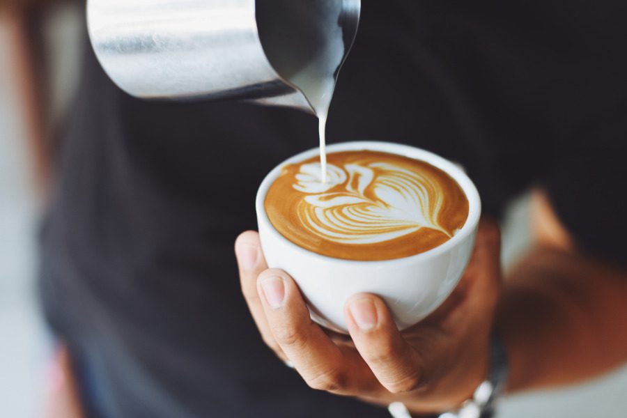 a barista pouring a latte