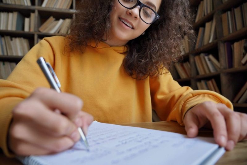 young poet with pen and glasses
