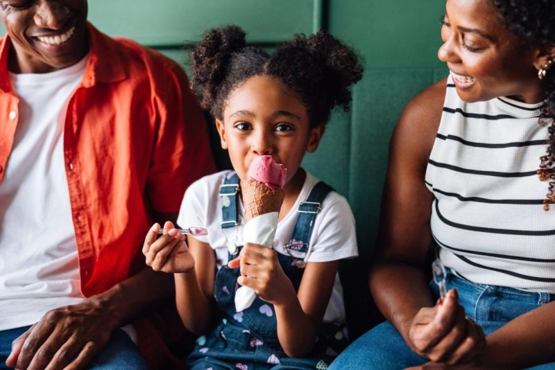 adorable child sits between parents holding an ice cream cone on Pennsylvania's ice cream trail.